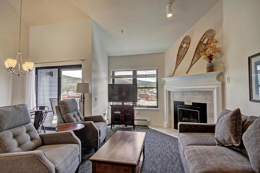 a living room with couches and a tv and a fireplace at River Mtn Lodge E301 in Breckenridge
