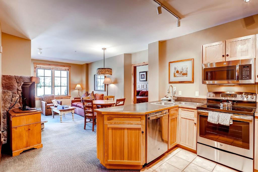 een keuken met houten kasten en een woonkamer bij Dakota Lodge 8513 in Keystone
