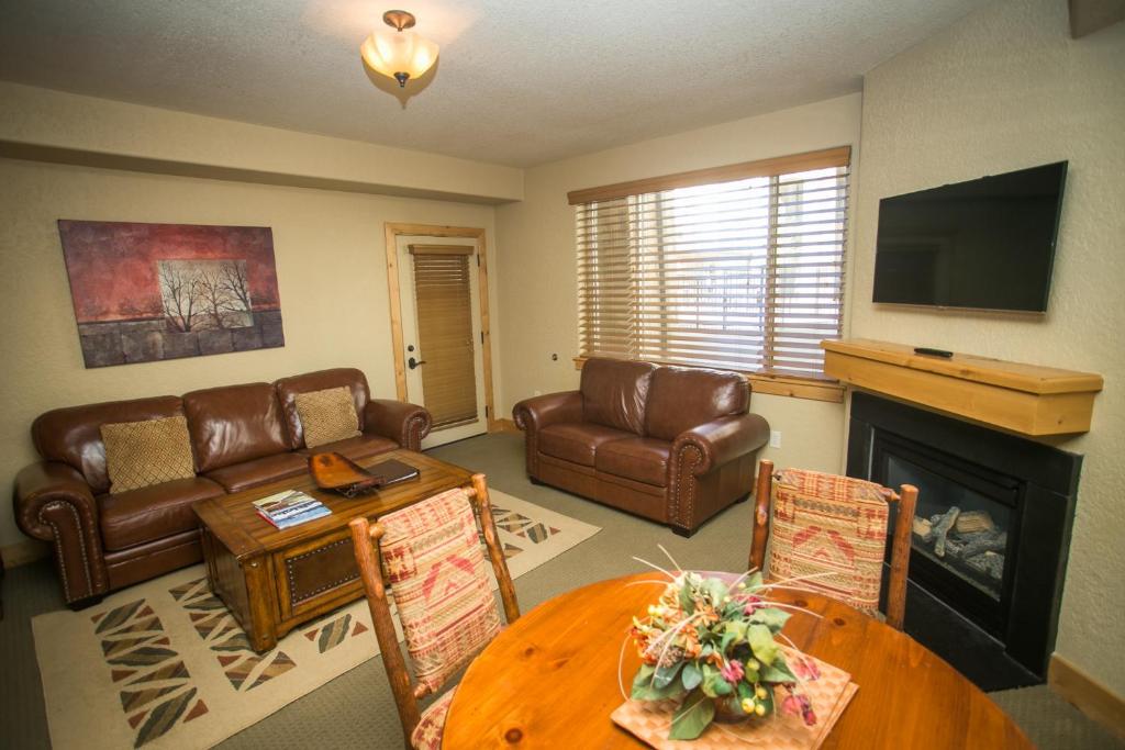 Una sala de estar con una mesa y una chimenea. en Silverado Lodge with Easy Pool Access, en Park City
