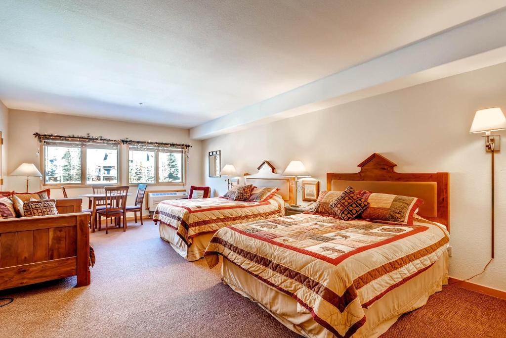 a bedroom with two beds and a table and chairs at Gateway 5070 in Keystone