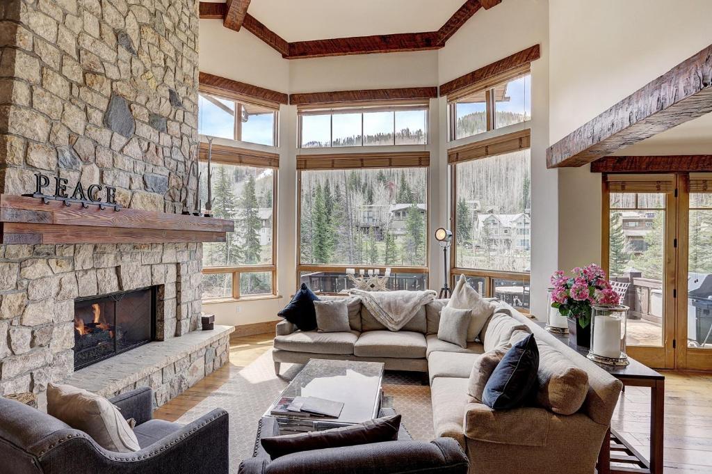 a living room with a large stone fireplace at Private Gore Creek Townhome in Vail