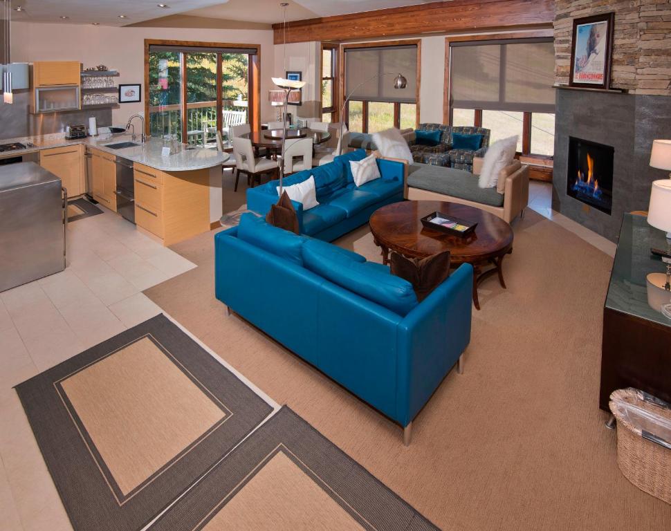 a living room with blue couches and a kitchen at Osprey 303 in Beaver Creek