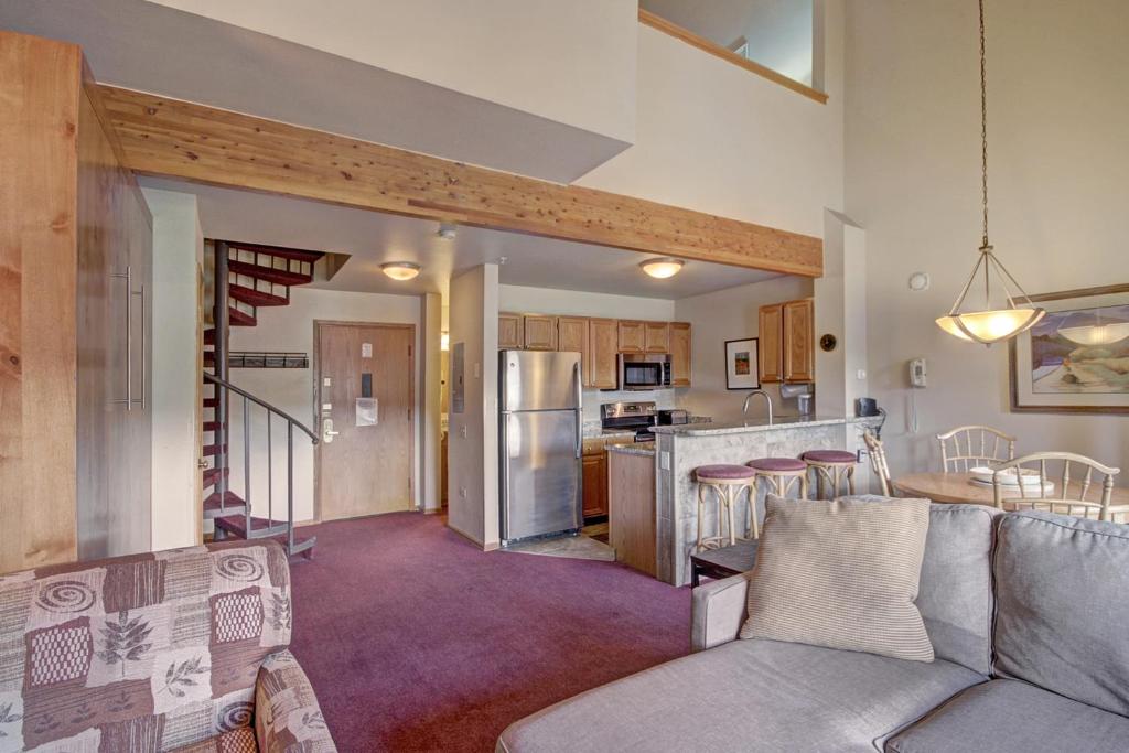 a living room and kitchen with a couch and a counter at River Mtn Lodge E304 in Breckenridge