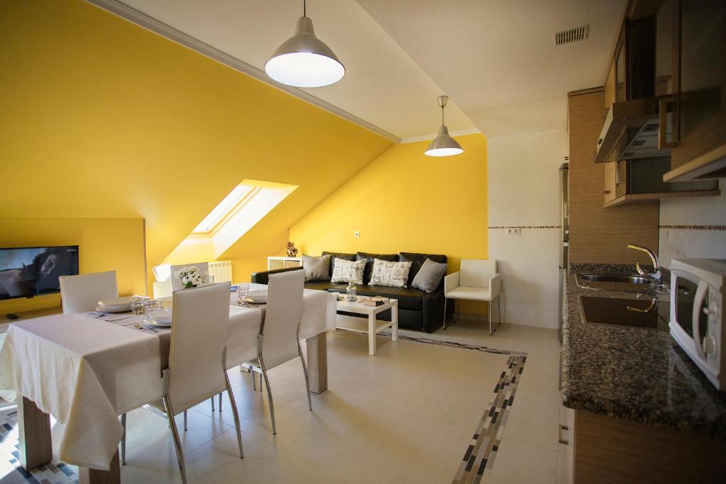 a living room with a table and a couch at dpCristal Ático Vistas al Camino in Sarria