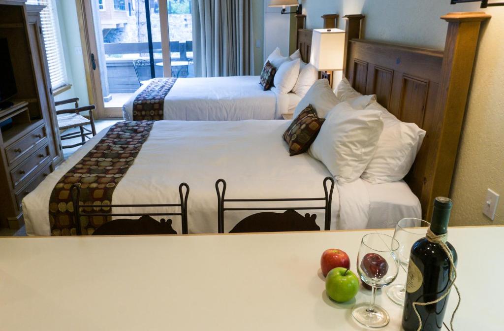 um quarto de hotel com duas camas e uma mesa com copos de vinho em Northstar Village 237 em Truckee