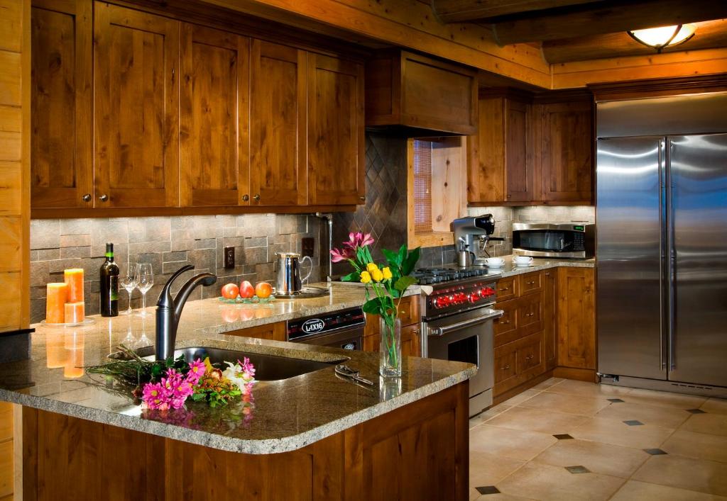 a kitchen with wooden cabinets and a stainless steel refrigerator at Trappers Cabin in Beaver Creek