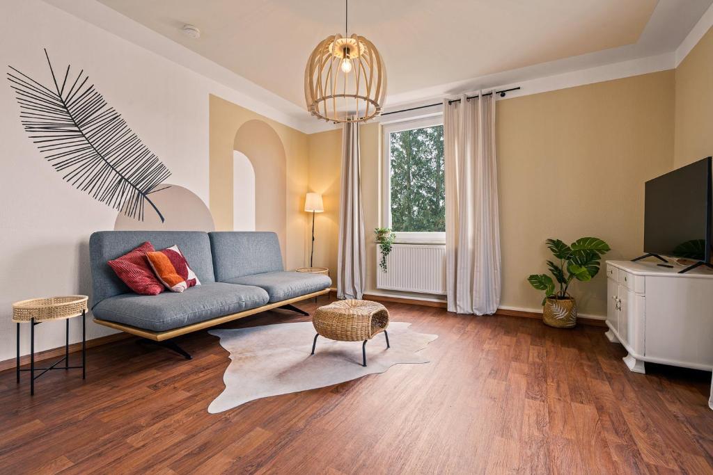 a living room with a blue couch and a tv at Wohnen bei der alten Dampflok inkl Balkon - 5 min zum Ravensburger Spieleland in Meckenbeuren