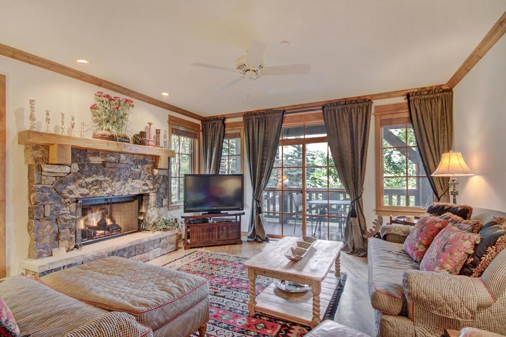 a living room with a fireplace and a television at Settler's Lodge 204 in Edwards