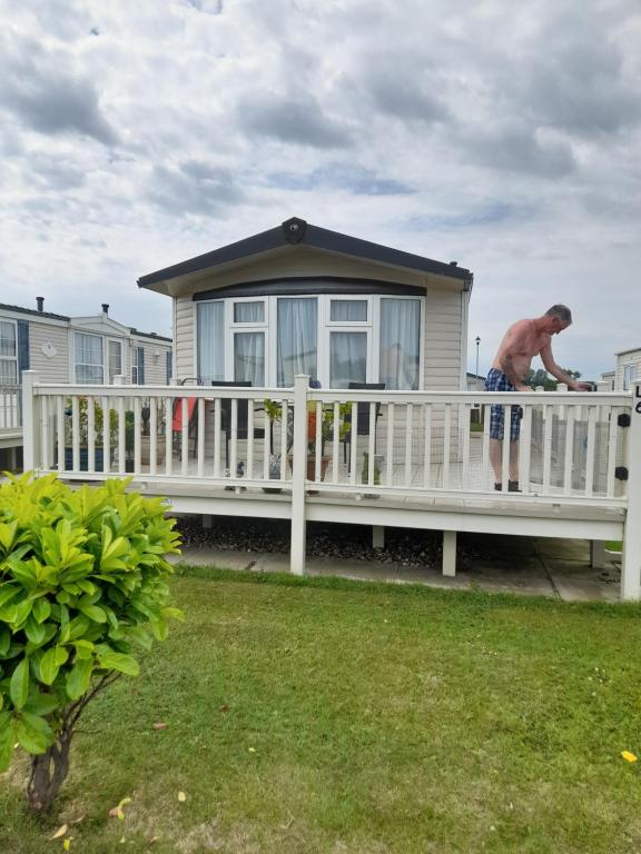 a man standing on the porch of a house at Millfield caravan site, caravan L6 in Ingoldmells