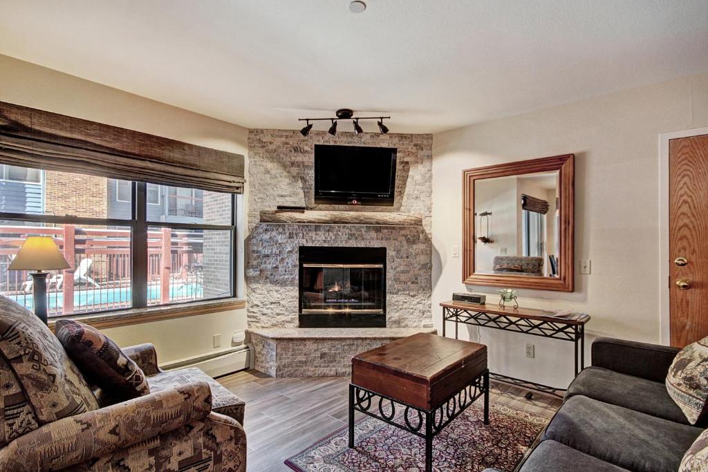 a living room with a fireplace and a tv at Spacious Condo In The Heart Of Breckenridge Condo in Breckenridge