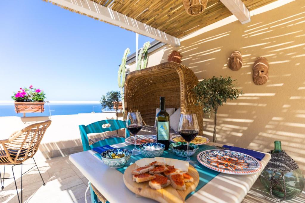 una tavola con un piatto di cibo e vino di Brezza Marina a Tropea