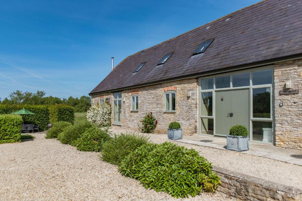 a stone house with a large glass door at Owl Barn in Aston