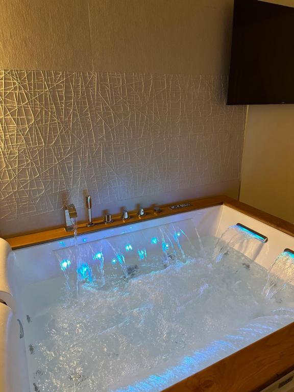 een bad gevuld met water met blauwe lichten erin bij Enjoyhousebracciano suite1 in Bracciano