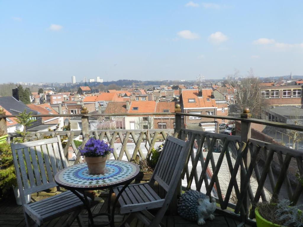 a table and chairs on a balcony with a view of a city at B&B Basilique in Brussels