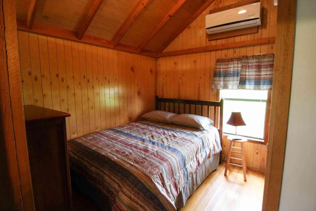 een slaapkamer met een bed in een houten hut bij Lakefront Cedar Cabin - 10 in Mead