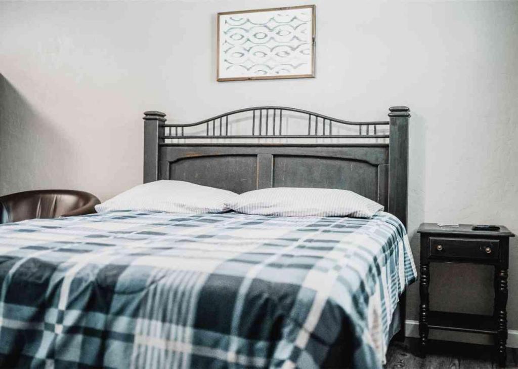 a bedroom with a bed with a blue and white checked blanket at Lake Access Quad-plex Kitchenette - 29 in Mead