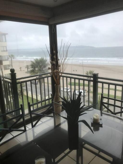 a table with a view of the beach from a balcony at Department la Serena Beach in La Serena