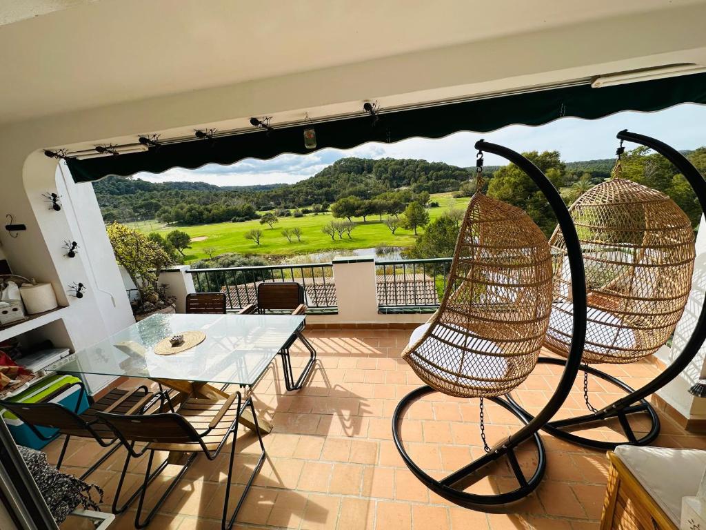 een balkon met een tafel en stoelen en uitzicht bij FLAT Surrounded by Nature WIFI & Pool & beach Nearby in Son Parc