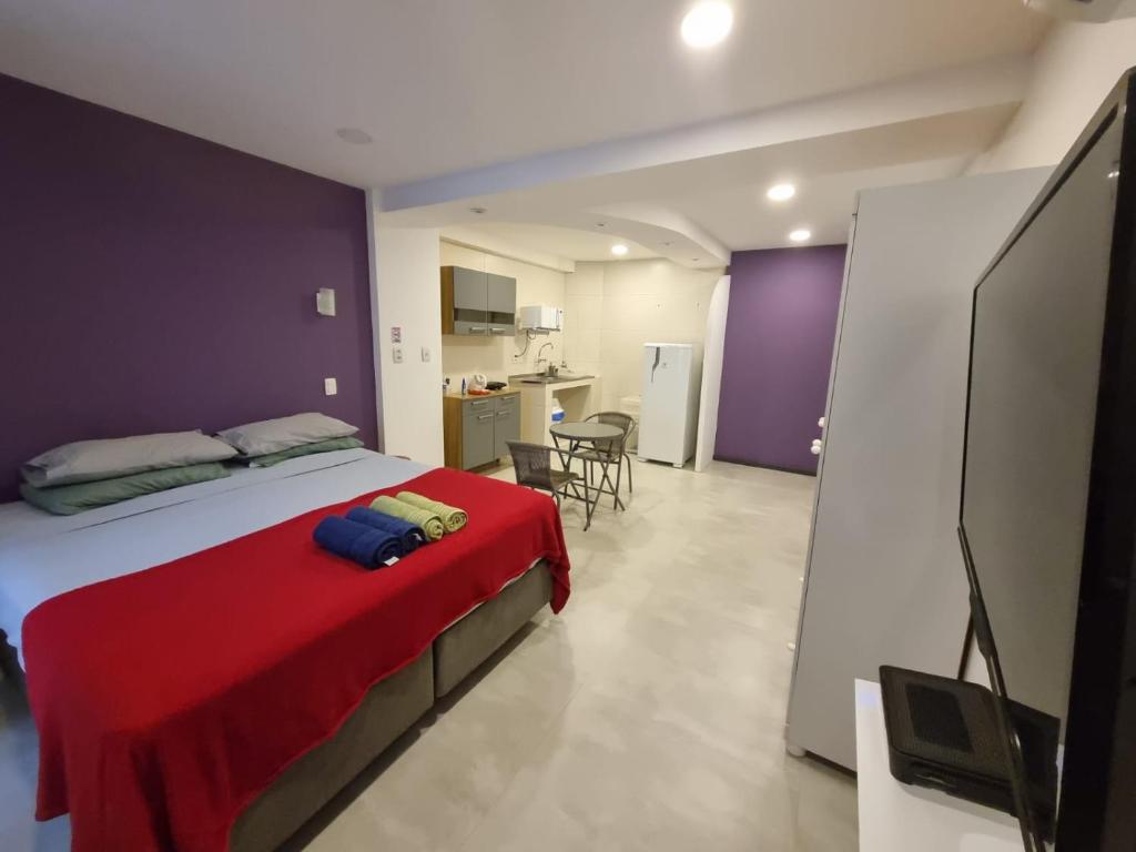 um quarto com uma cama com um cobertor vermelho em Suítes/Studios Privados Copacabana no Rio de Janeiro