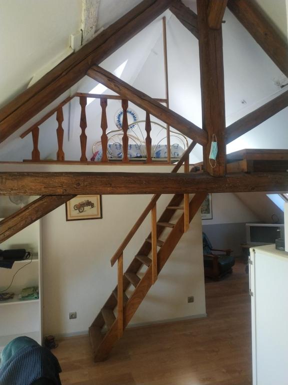 a staircase in a loft conversion with wooden beams at Entre vigne et rivière in Écuelles