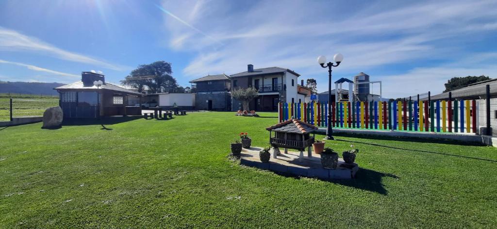 einen großen Hof mit einem Zaun und einem Grasfeld in der Unterkunft El Rato Apartamentos Rurales in Navia