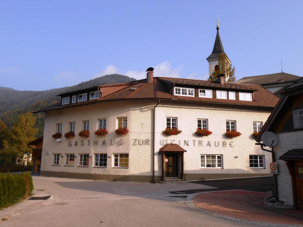 a large white building with a clock tower on top at Apartment Weintraube in Rohr im Gebirge