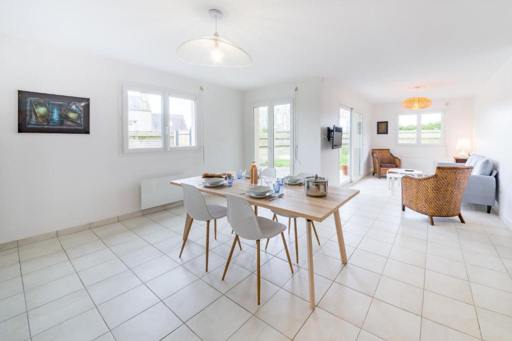 a dining room and living room with a table and chairs at TY BIHAN - Charmante maison de plein-pied proche mer in Ploudalmézeau