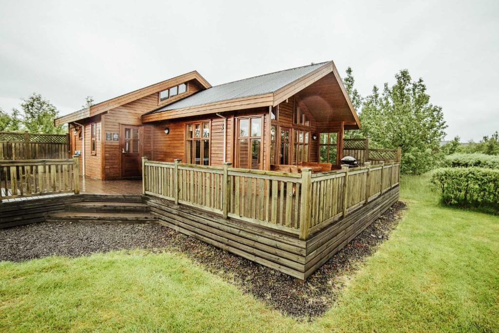 uma cabana de madeira com um alpendre e um deque em Minniborgir Cabins em Minni-Borg