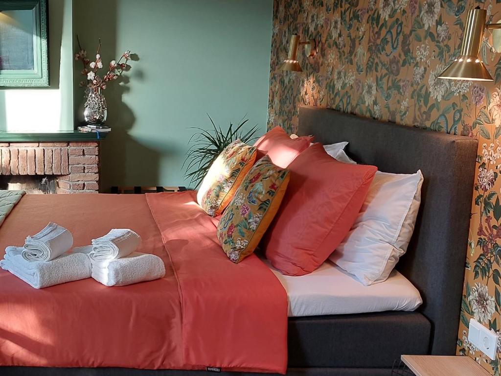 Una cama con almohadas y toallas encima. en Stadsslaperij B&B, en Tilburg