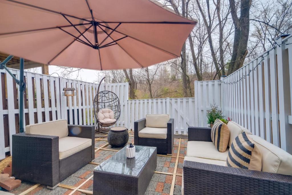 a patio with chairs and a table and an umbrella at Quaint Arlington Vacation Rental with Patio! in Arlington