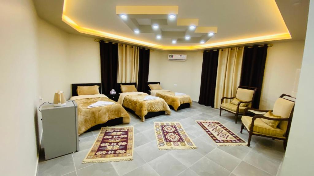 a hotel room with two beds and chairs and rugs at Petra Olive House in Wadi Musa