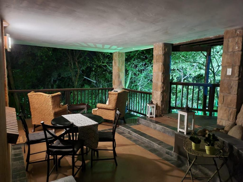 eine Veranda mit Stühlen und einem Tisch auf dem Balkon in der Unterkunft Tranquil Garden Nest in Nelspruit