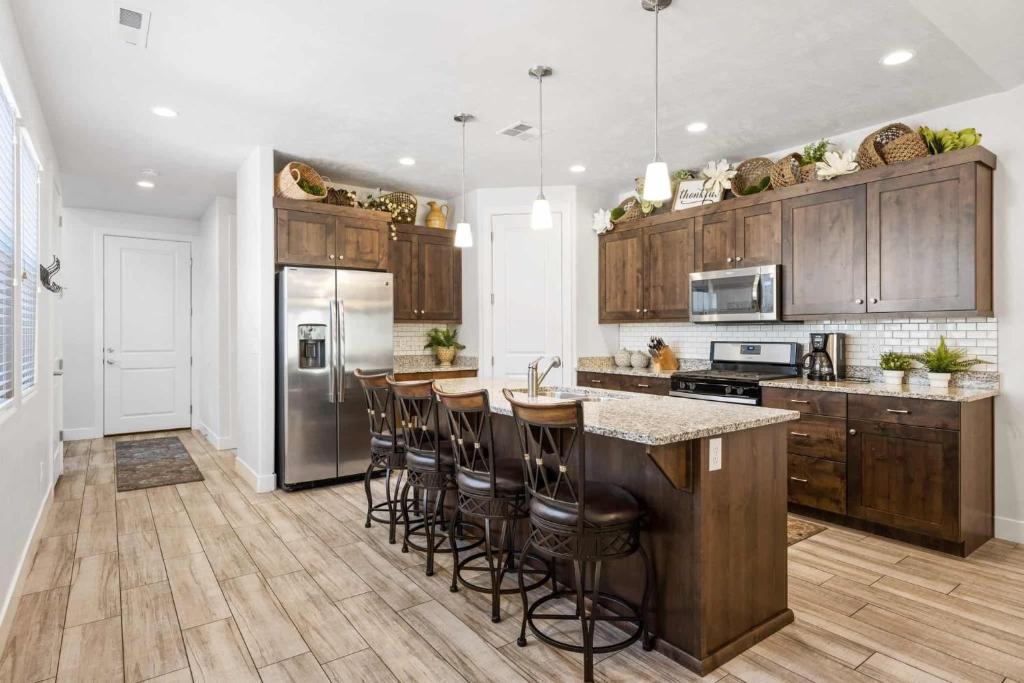 eine Küche mit Holzschränken und eine Insel mit Barhockern in der Unterkunft Desert Pearl #59 townhouse in Santa Clara