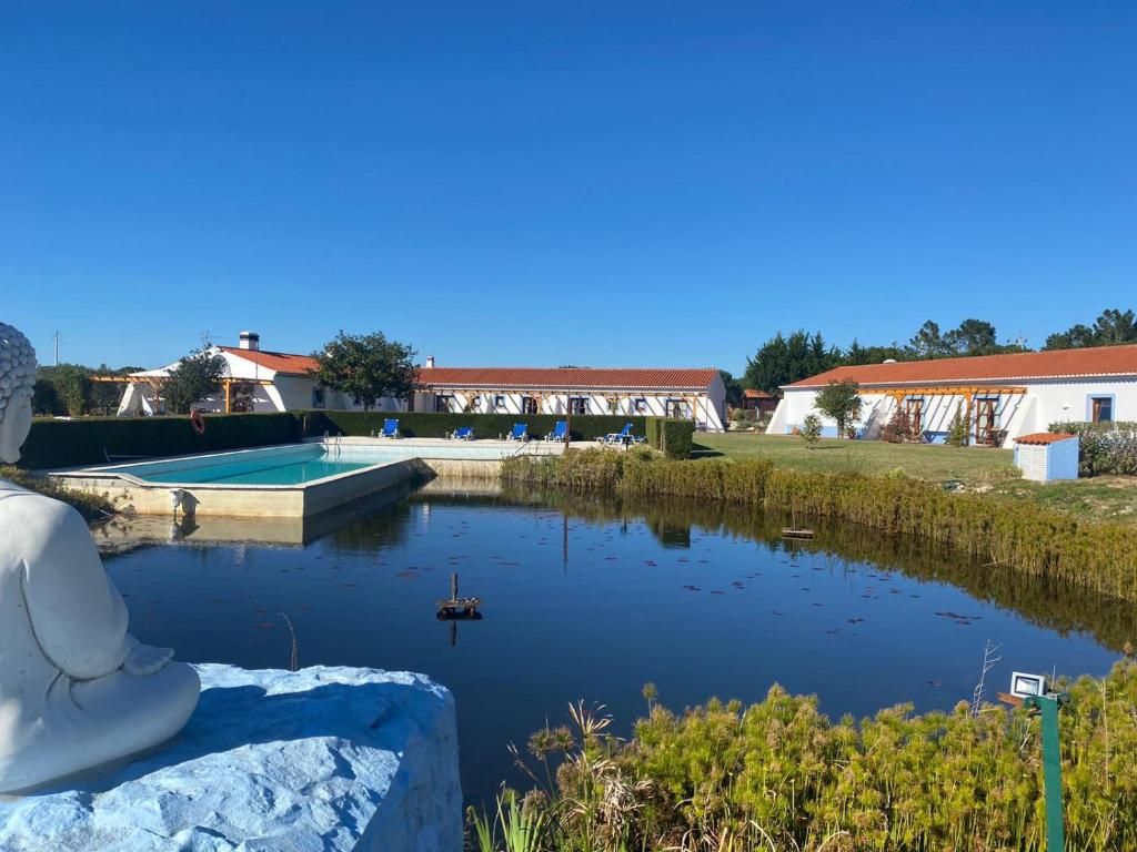 Eine Frau, die auf einem Felsen sitzt und einen Teich ansieht. in der Unterkunft Casa Vicentina in Odeceixe