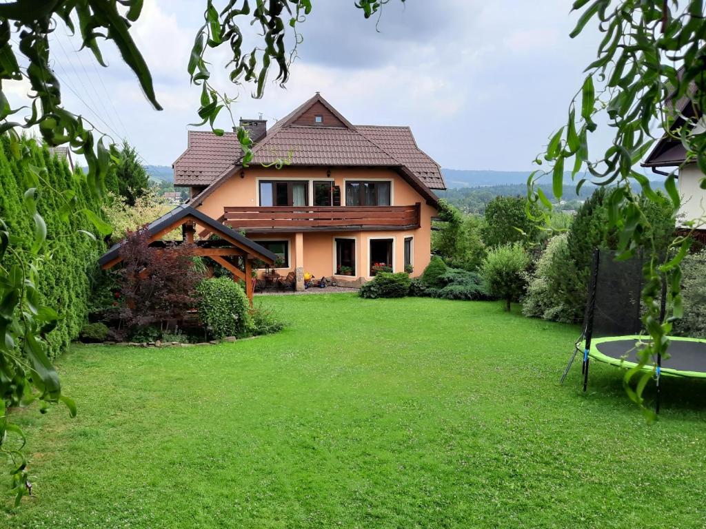 Skawa的住宿－Pod Jednym Dachem，前面有绿色草坪的房子