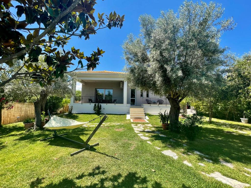 a house with a hammock in the yard at Apollon Paian , Luxury Nature Relax in Lefkada Town