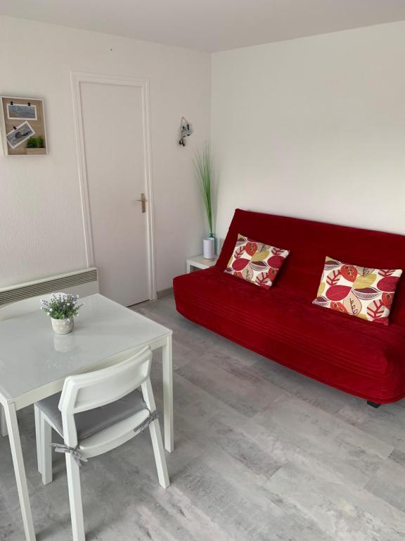 un salon avec un canapé rouge et une table dans l'établissement Baie Island à 50 m de la plage…, à Fort-Mahon-Plage