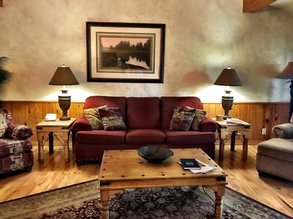 un soggiorno con divano e tavolo di C15, Two bedroom, two bath log-sided, luxury Harbor North cottage with hot tub cottage a Mount Ida