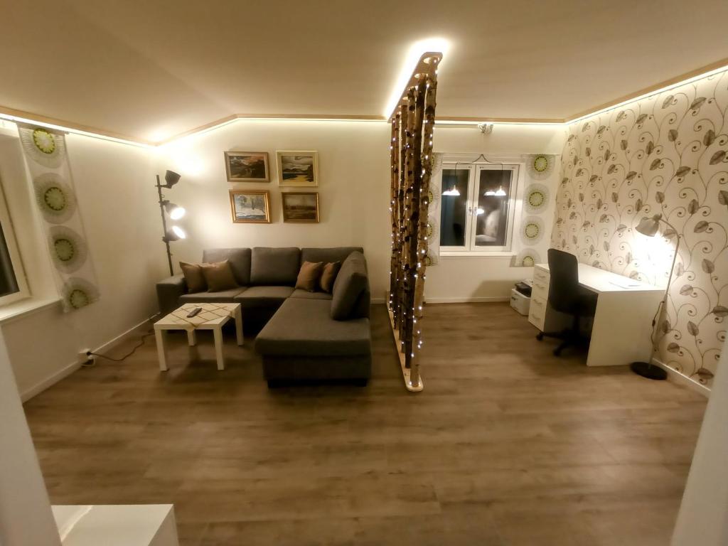 a living room with a couch and a mirror at Exklusiv flat with office 25 min from Östersund 