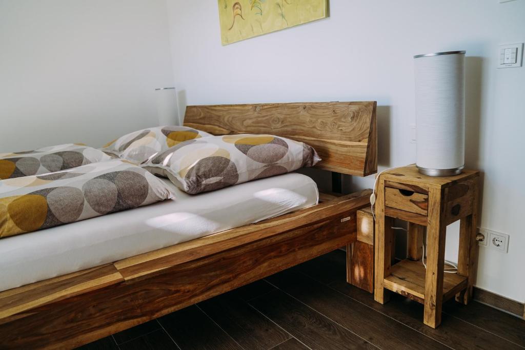1 dormitorio con cama de madera y mesa en Ferienwohnung Im Schafftl 1, en Ramsthal