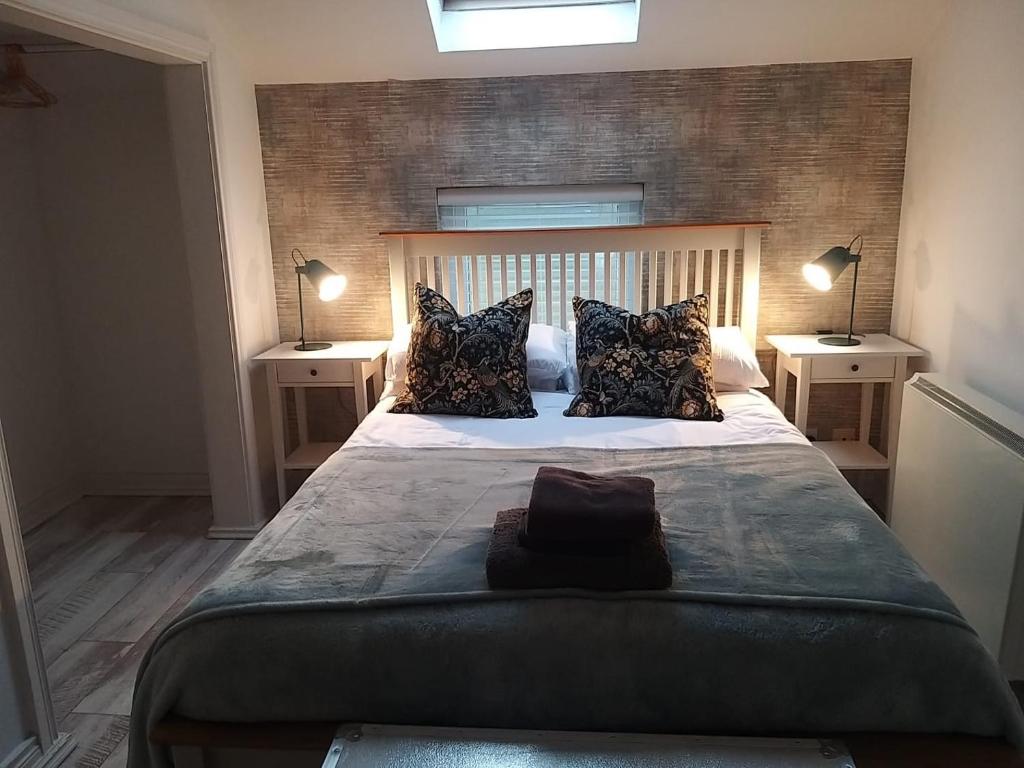 a bedroom with a large bed with two night stands at Rosebank Apartment no 3 in Moville