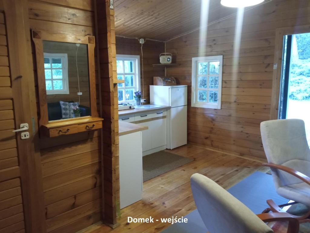 a kitchen in a tiny house with wooden walls at Domek i jurta nad rzeką in Kościerzyna
