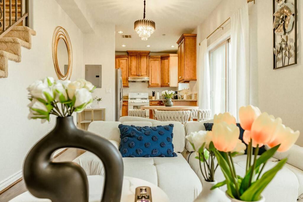 een woonkamer met een bank en een tafel met bloemen bij Sweet Modern House 7mins to Disney in Fullerton