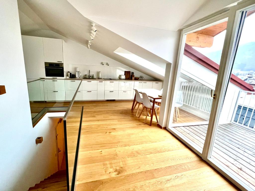 a kitchen with a dining table and a large window at Gmunden Skyline in Gmunden