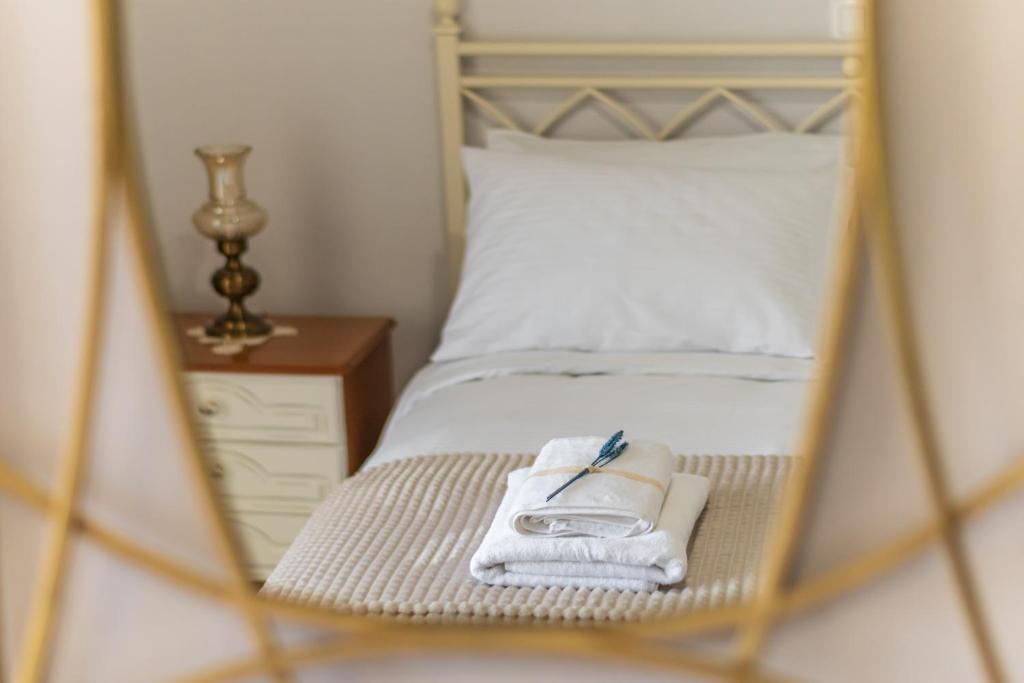 a mirror reflection of a bed with towels on it at 4keys House Superior in Tripoli