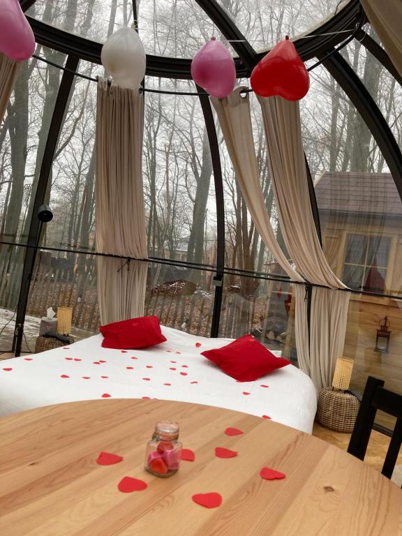 um quarto com uma cama com corações vermelhos em Le Dôme de Namur - Une nuit insolite dans les bois em Champion