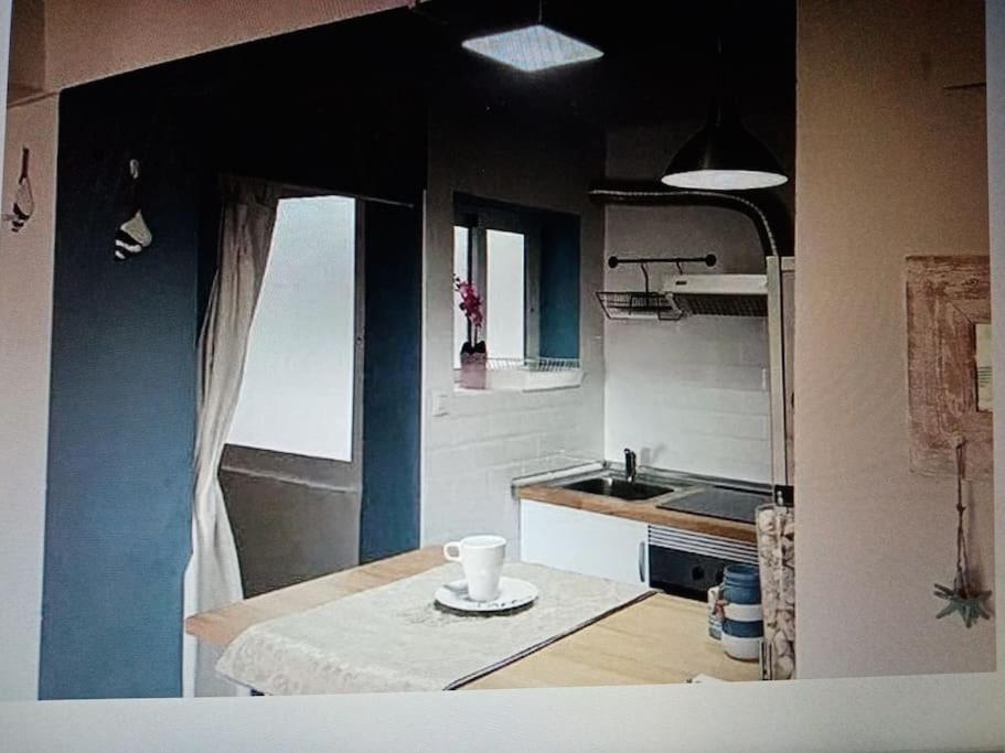 una cocina con fregadero y una mesa con una taza. en Nice apartment on the coast to relax and work, en Cartagena