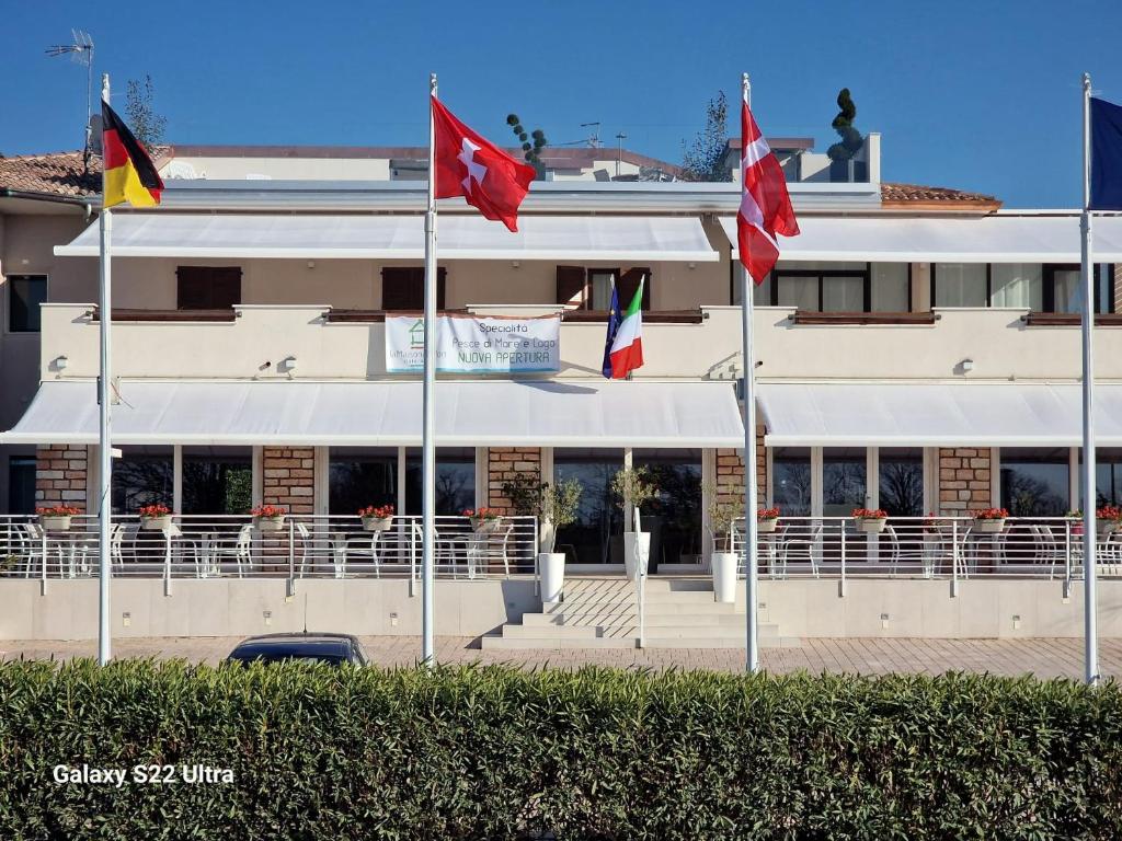een gebouw met vlaggen ervoor bij La Maison du Port in Lazise
