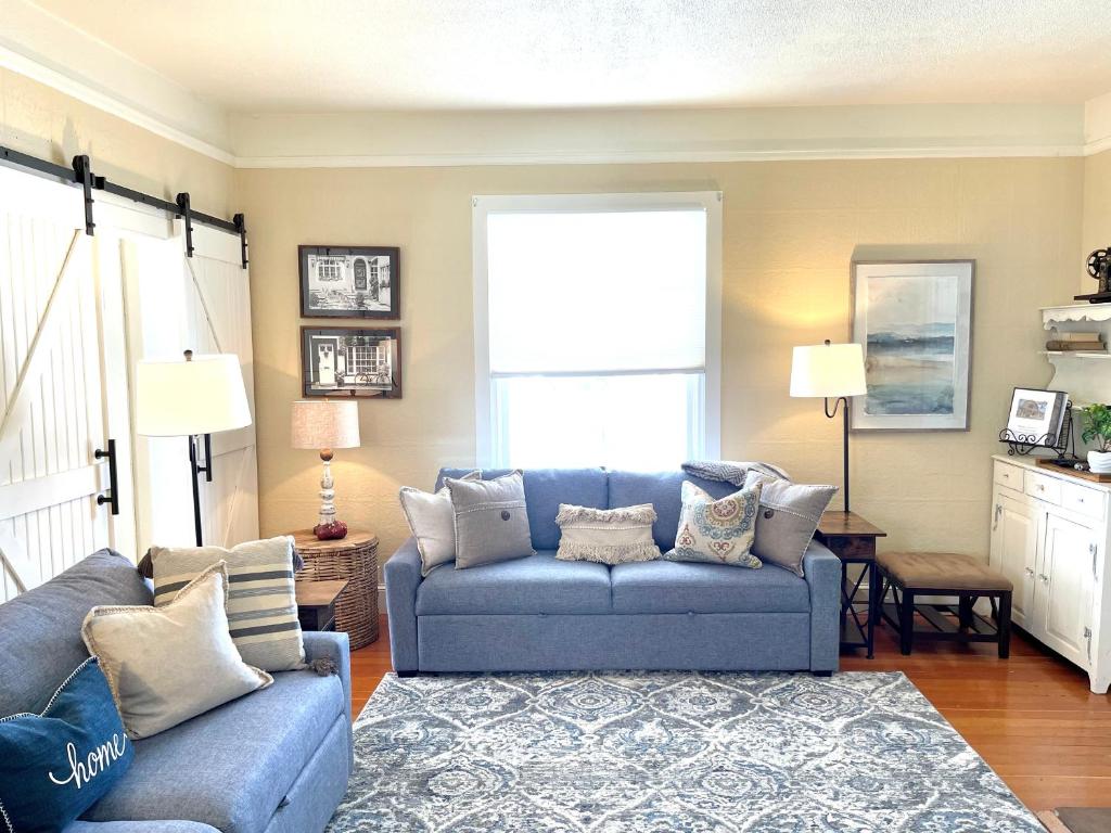 sala de estar con sofá azul y ventana en Spacious City House en Colorado Springs
