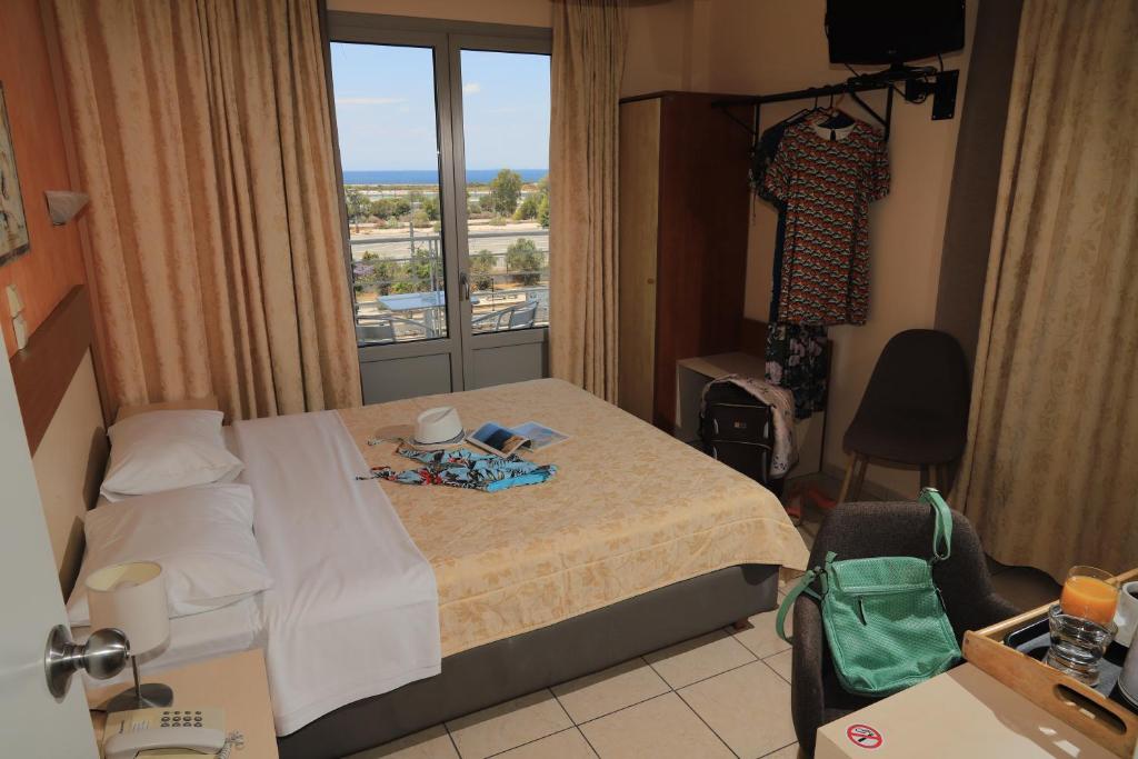 a hotel room with a bed and a window at IKAROS Hotel ELLINIKO in Athens